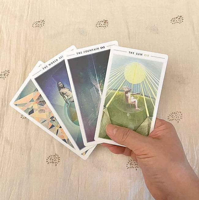 ファウンテンタロット - fountain tarot 6 - カードの大きさはこのくらい。カードを持っている手は、手の付け根から中指の先までで約17cmです。「太陽」のカードのお子様が1人だからウェイト版なのか？不思議なカードです。
