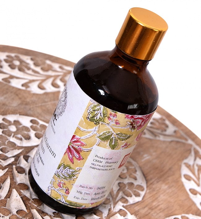 【6個セット】ダンワンタラム タイラム[Dhanwantharam Thailam 100ml] 3 - 斜めから撮影しました。かわいいガラス瓶にウッドブロックの伝統模様をあしらいました。