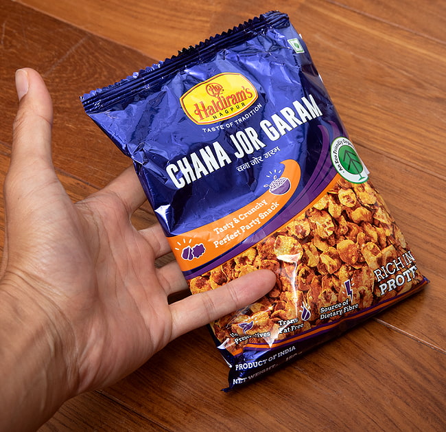 【6個セット】インドのお菓子 潰しチャナ豆のスパイシースナック - チャナ　ジョル　ガラム - CHANA JOR GARAM 150g[HARDIRAMs] 5 - サイズ比較のために手と一緒に