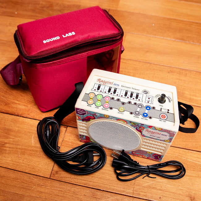 タンプーラマシン - Ragini Digital Electric Tanpula 9 - こちらはケース色がレッドの例です。また、ケースの色にかかわらず、付属品としてインドの電源ケーブルと日本の電源ケーブル（メガネケーブル）が各一本付属します。