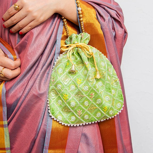 インドのきらきらミニバッグ・サリー等へオススメの巾着 格子&リーフ系片面 4 - 腕にかけてみた様子。コンパクトなサイズです。