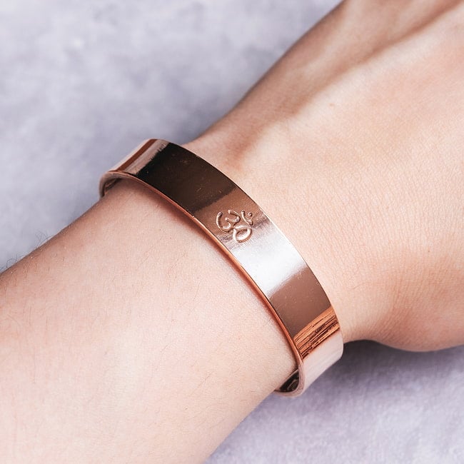 インドの純銅製バングル さり気ないオーンが手元を彩る　鏡面プレーンデザイン マグネット6個内蔵  アーユルヴェーダやプージャで親しまれる銅 ユニセックスの写真ブレスレット,バングル,アクセサリー,フリーサイズ,カッパー,銅,純銅,インドアクセサリー,アーユルヴェーダ,プージャ,マグネット内蔵,磁石内蔵,オーン,オーム,OM,鏡面,プレーン,シンプル,ユニセックス,銅バングル