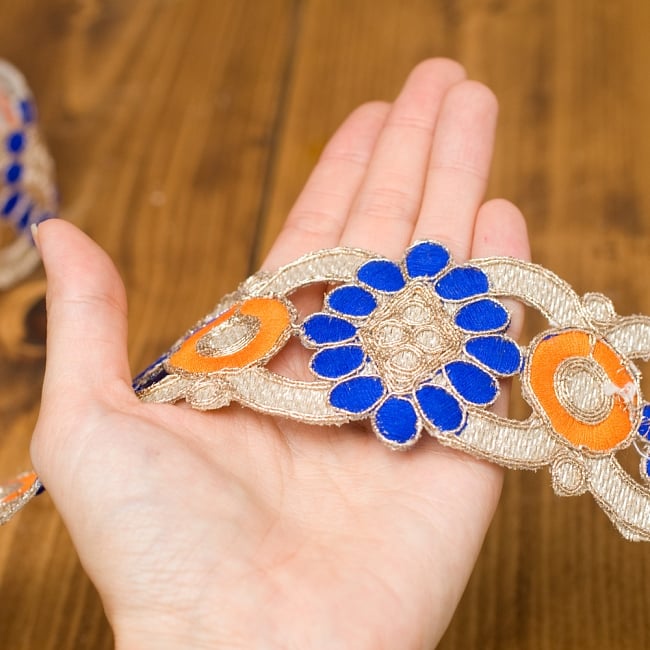 金糸刺繍チロリアンテープ (メーター売り・幅 約5cm) - ブルー・オレンジ 4 - 手に取ってみました。金糸が美しく存在感のあるテープです。