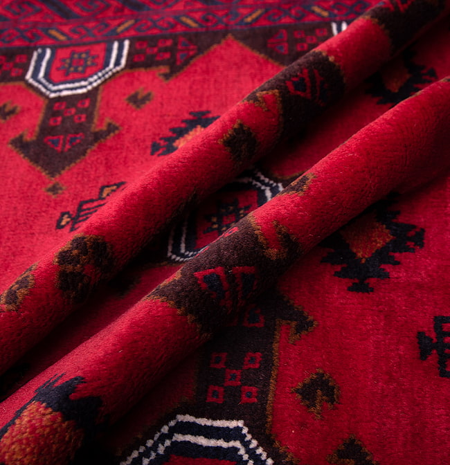 遊牧民バローチの手織り絨毯【約146cm x 82cm】 5 - 絨毯の感じがわかるように、波を作って撮影しました