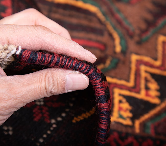 遊牧民バローチの手織り絨毯【約190cm x 101cm】 11 - 厚さはこんな感じです。厚すぎず薄すぎず、ちょうどよいです。