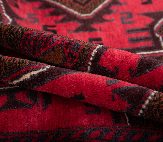 遊牧民バローチの手織り絨毯【約193cm x 107cm】 4 - 絨毯の感じがわかるように、波を作って撮影しました