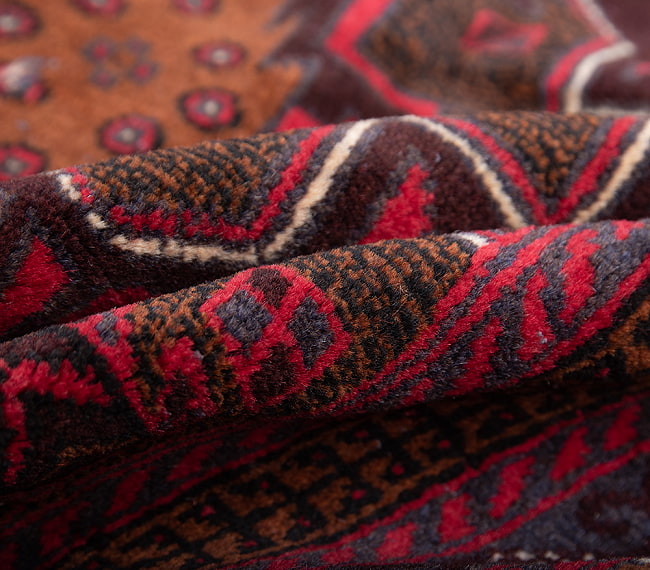 遊牧民バローチの手織り絨毯【約193cm x 107cm】 5 - 絨毯の感じがわかるように、波を作って撮影しました