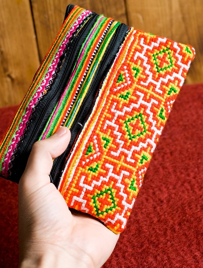 モン族刺繍の三連ジッパーサブバッグ -たて約15cm x 約よこ25cm 【アソート】 8 - 手とサイズを比較してみました。男性の手よりもずっと大きいです。(同サイズの写真です)