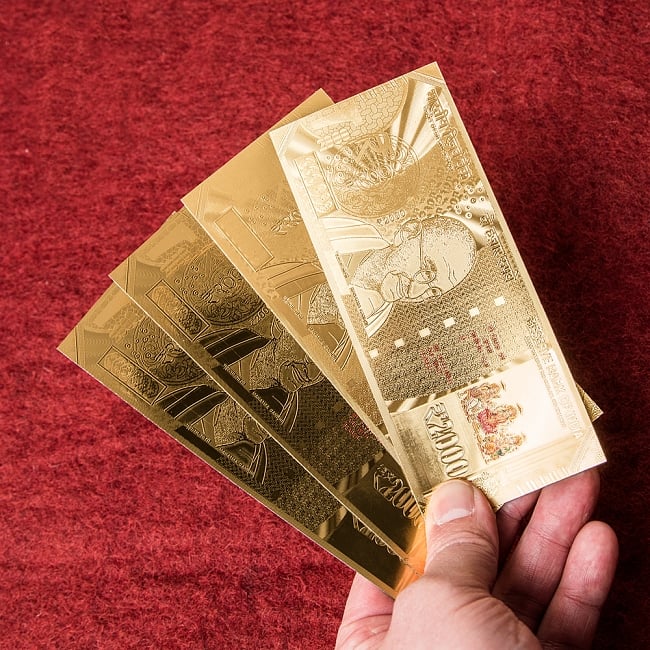 2000ルピー札モチーフのゴールドカードの写真1枚目です。光を受けて綺麗に輝きます。この中から1枚お送り致します。金運,財布,風水,お札,ルピー,ガンジー,ガネーシャ,ラクシュミー,サラスヴァティー