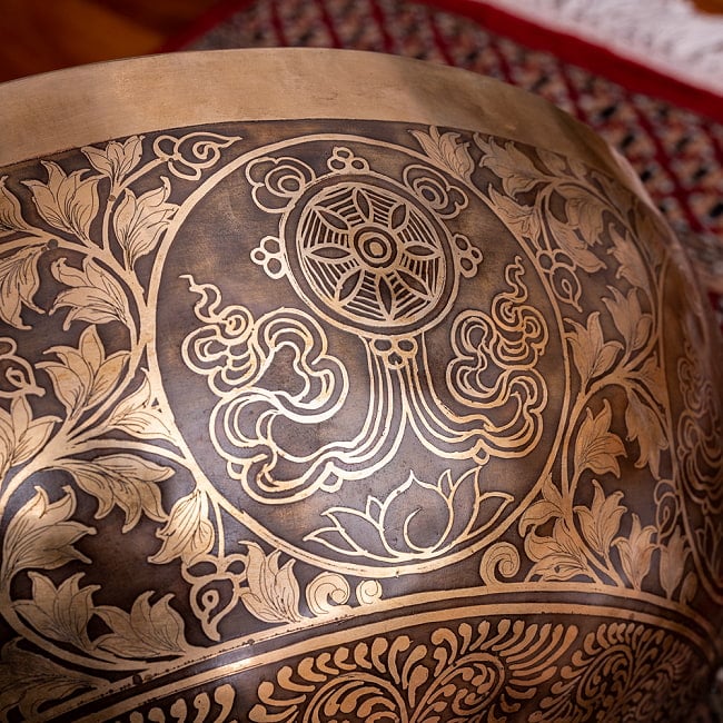 【一点物】仏足石模様と7チャクラ 幸運の八吉祥文様 細密彫りチベタンアンティックシンギングボウル【音階:Ab】約5435g(スティック付属) 18 - 釈迦の教えを車輪に例えた法輪(チャクラ)。