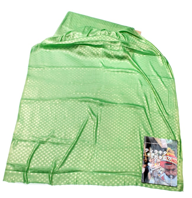 〔1m単位切り売り〕グリッターペイズリーのサテン生地布〔幅約112cm〕 - 緑 6 - 布を広げてみたところです。横幅もしっかり大きなサイズ。右下にあるのはサイズ比較用の当店A4サイズカタログです。