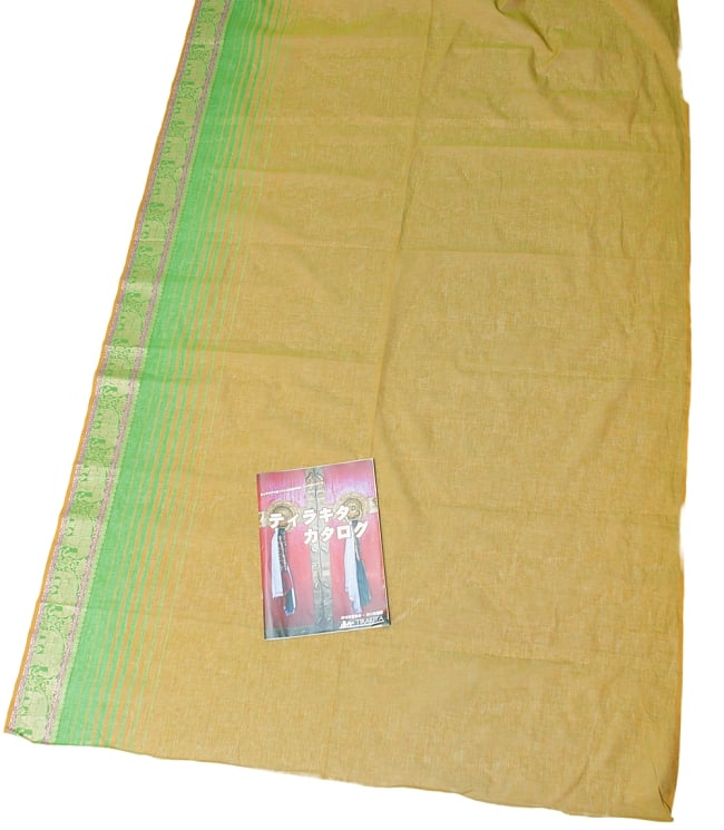 〔1m切り売り〕南インドのハーフボーダー・シンプル・コットン生地 - 茶色グリーン×緑象さん〔幅約110cm〕の写真1枚目です。A4の冊子と撮影しました。布の広がりがわかりますね。切り売り,量り売り布,アジア布 量り売り,手芸,裁縫,生地,アジアン,ファブリック