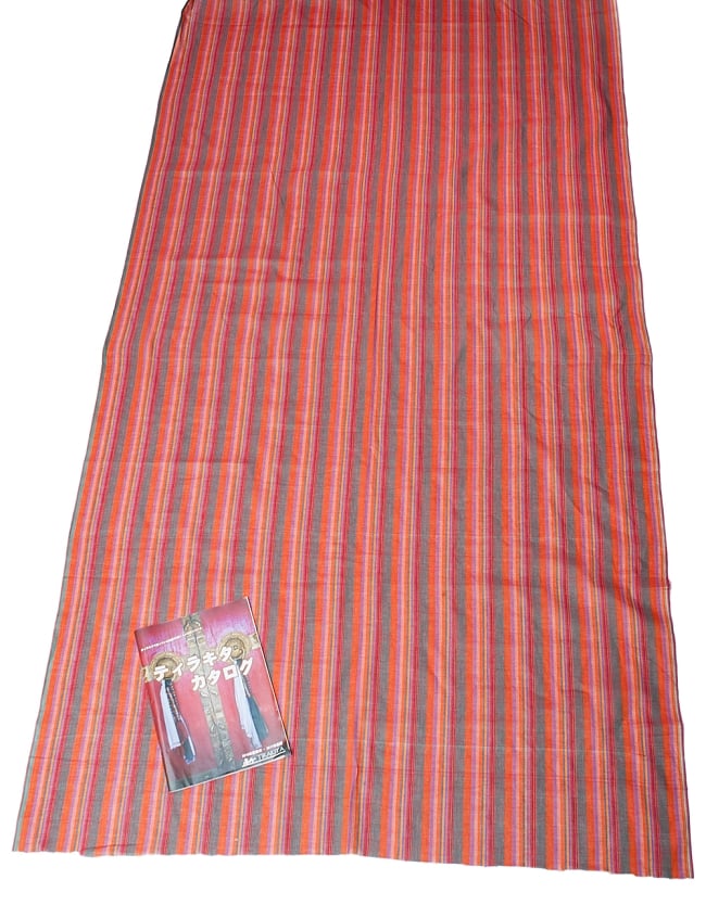 〔1m切り売り〕南インドのストライプ布 - オレンジ系 〔幅約111cm〕 6 - A4の冊子と並べてみました。布と模様の広がりがわかりますね。