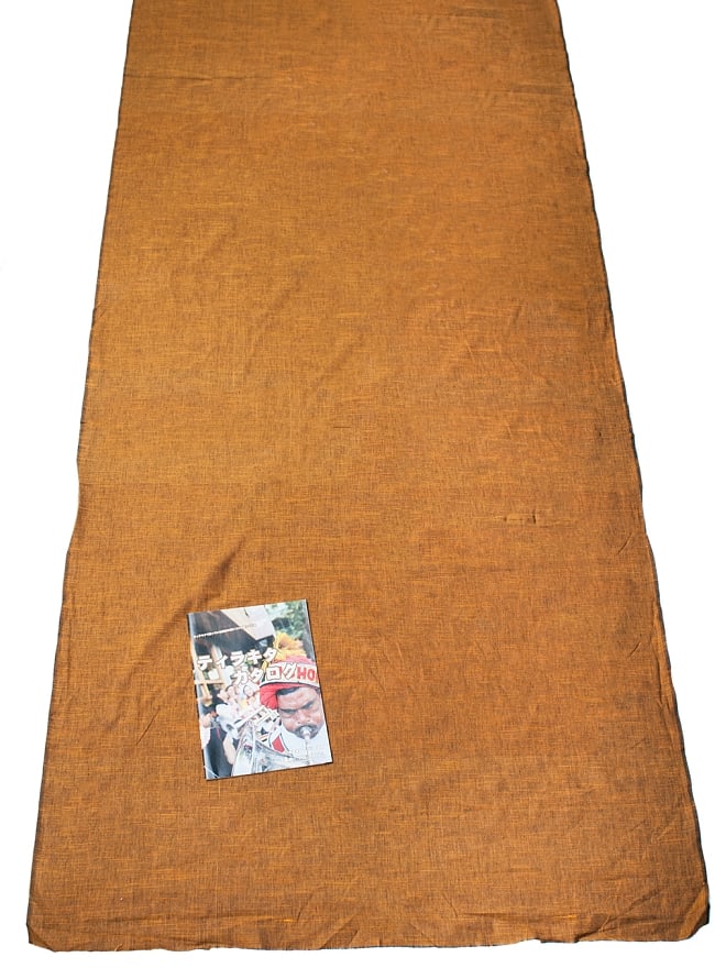 〔1m切り売り〕インドのシンプルコットン布 - 黄土〔幅約110cm〕 6 - A4の冊子と並べてみました。広がりがわかりますね。