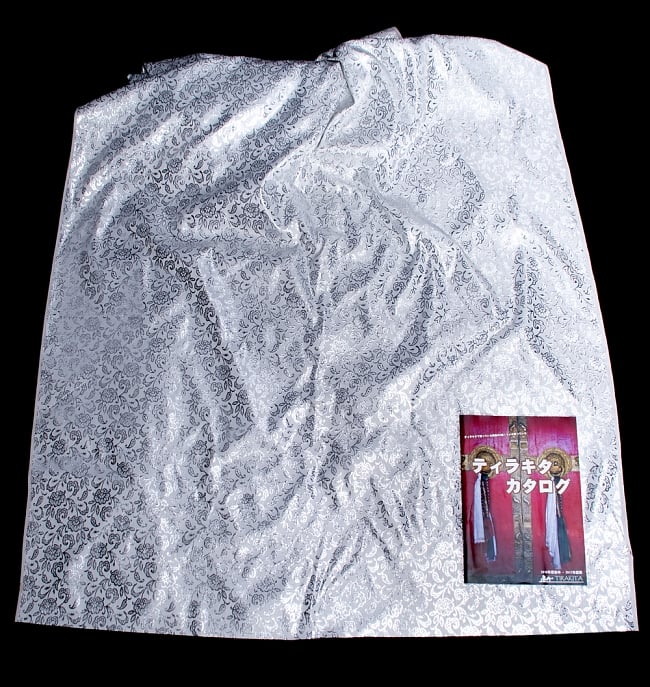 〔1m切り売り〕インドの銀糸入り伝統模様布〔109cm〕 - ホワイト 6 - 布を広げてみたところです。横幅もしっかり大きなサイズ。布の上に置かれているのはサイズ比較用の当店A4サイズカタログです。