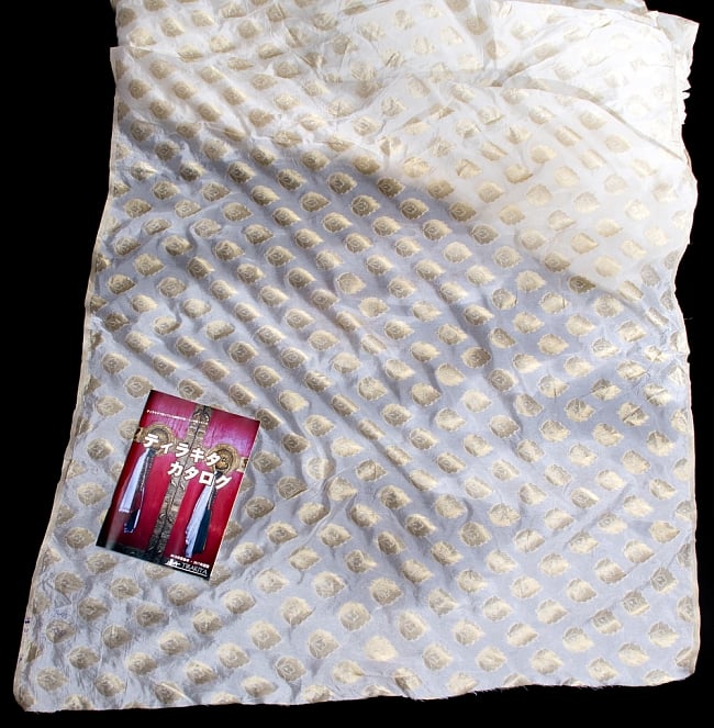 〔1m切り売り〕インドの伝統模様布〔115cm〕 - ホワイト 6 - 布を広げてみたところです。横幅もしっかり大きなサイズ。布の上に置かれているのはサイズ比較用の当店A4サイズカタログです。