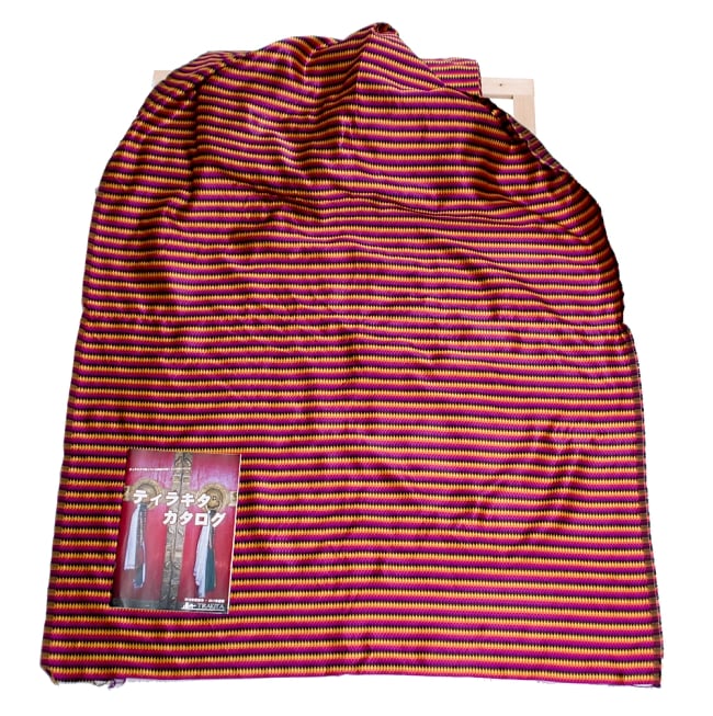 〔1m切り売り〕インドのマルチカラークロス〔109cm〕 - 赤紫×黒×黄色 6 - 色違いの布を広げてみたところです。横幅もしっかり大きなサイズ。布の上に置かれているのはサイズ比較用の当店A4サイズカタログです。