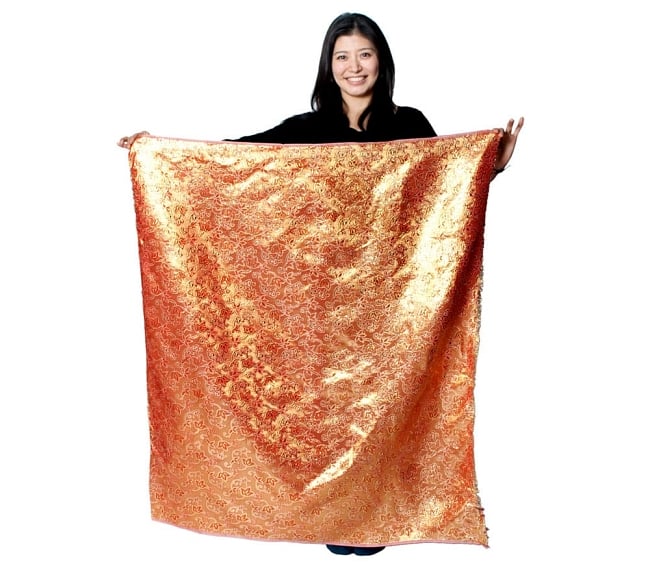 〔1m切り売り〕インドの伝統模様布〔幅約111cm〕 - グリーン×カッパー 7 - 同じインドからやってきた『〔1m切り売り〕インドの伝統柄ゴールドプリント光沢布〔幅約100cm〕』を、1mカットしてモデルさんに持ってもらった写真です。切り売りの布は基本的に横幅100cm前後と大きいので、ご覧の通り色々な用途に使えそうです。ご注文個数に応じた長さにカットしてお送りいたします。