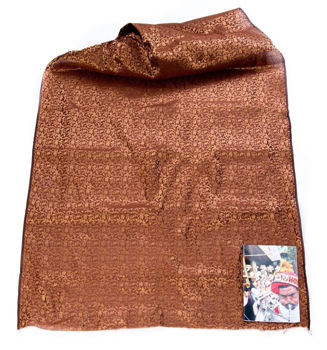 〔1m切り売り〕インドの伝統模様布〔幅約111cm〕 - ブラウン 2 - 布を広げてみたところです。横幅もしっかり大きなサイズ。布の上に置かれているのはサイズ比較用の当店A4サイズカタログです。