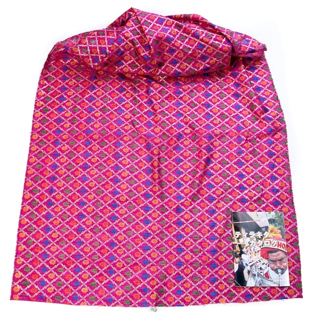 〔1m単位切り売り〕インドの伝統模様布〔幅約110cm〕 - マゼンタ 2 - 布を広げてみたところです。横幅もしっかり大きなサイズ。布の上に置かれているのはサイズ比較用の当店A4サイズカタログです。