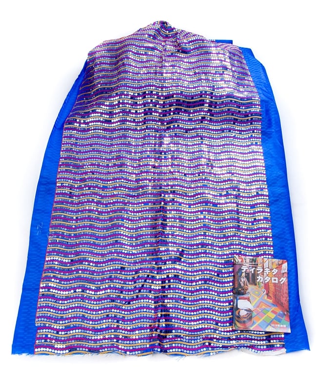 〔1m切り売り〕インドのスパンコールクロス布〔112cm〕 - 青紫 3 - 布を広げてみたところです。横幅もしっかり大きなサイズ。布の上に置かれているのはサイズ比較用の当店A4サイズカタログです。