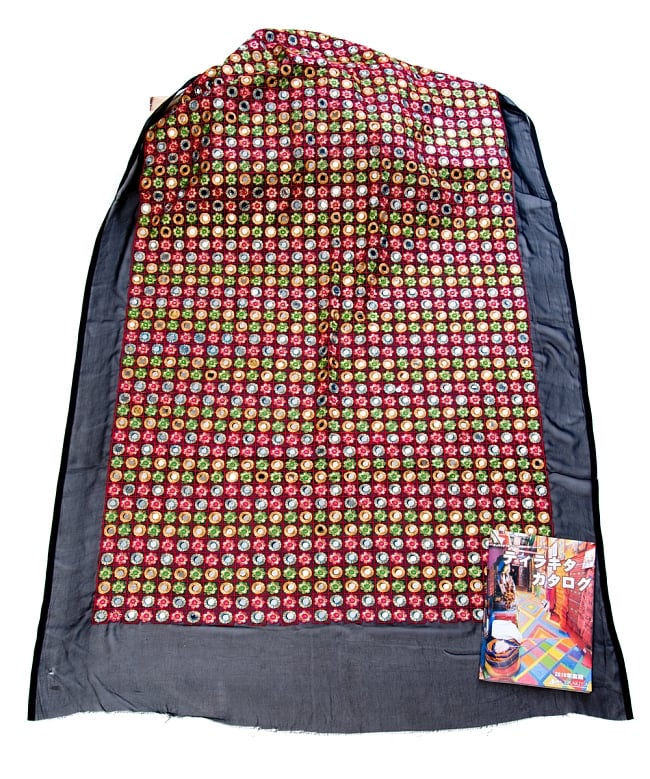 〔1m単位切り売り〕ミラーワーク付きラジャスタンの刺繍布〔107cm〕 - ブラック 3 - 布を広げてみたところです。横幅もしっかり大きなサイズ。布の上に置かれているのはサイズ比較用の当店A4サイズカタログです。