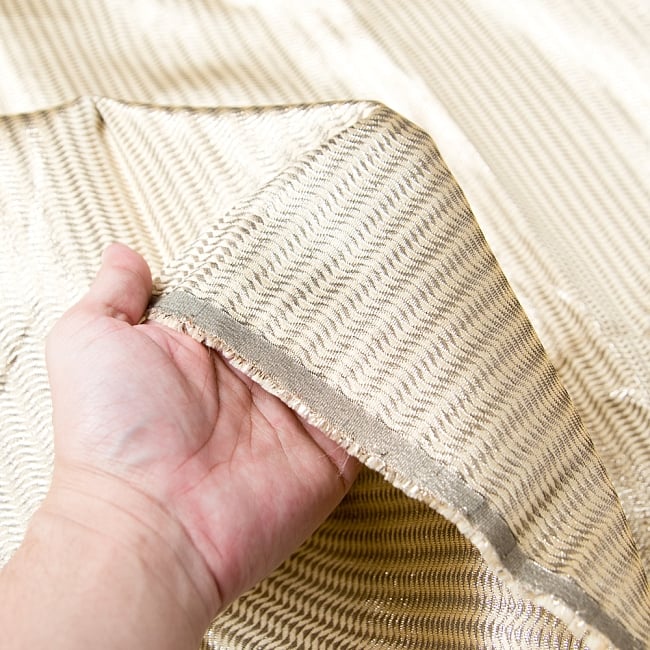 〔1m切り売り〕インドの伝統模様ゴールドプリント布〔幅約110cm〕 5 - 手に持ってみました。