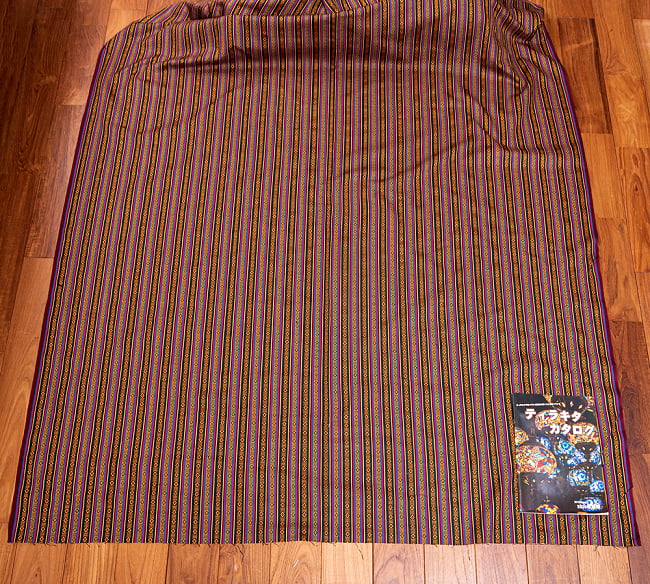 【3個セット】〔50cm切り売り〕ネパール伝統のコットン織り生地　薄手〔幅約150cm〕 3 - 生地を広げてみたところです。右下にあるのはサイズ比較用のA4サイズカタログです。