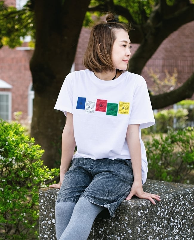 タルチョーTシャツの写真1枚目です。身長150cmのモデルさんがMサイズのホワイトを着用したところです五色旗,タルチョ,タルチョー,ルンタ,マニ旗,Tシャツ,半袖 Tシャツ,Tシャツ,ユニセックス,ネパールTシャツ